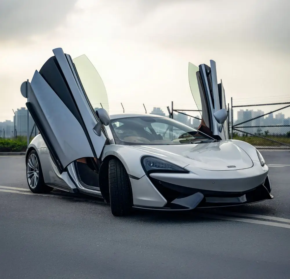 White Mclaren sports car parked in the middle of the road